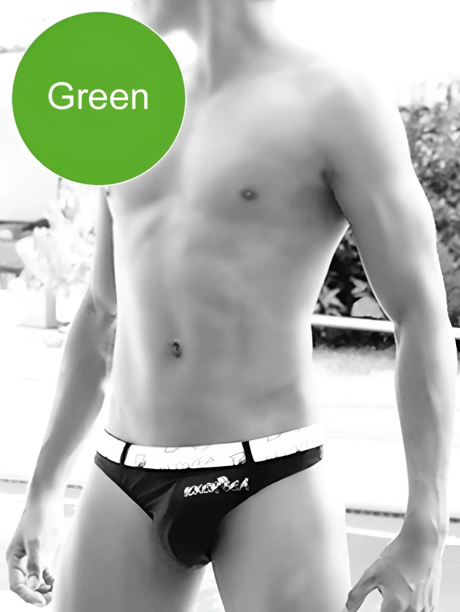 Black briefs with white waistband featuring exotica brand name in black lettering, swimwear back side view