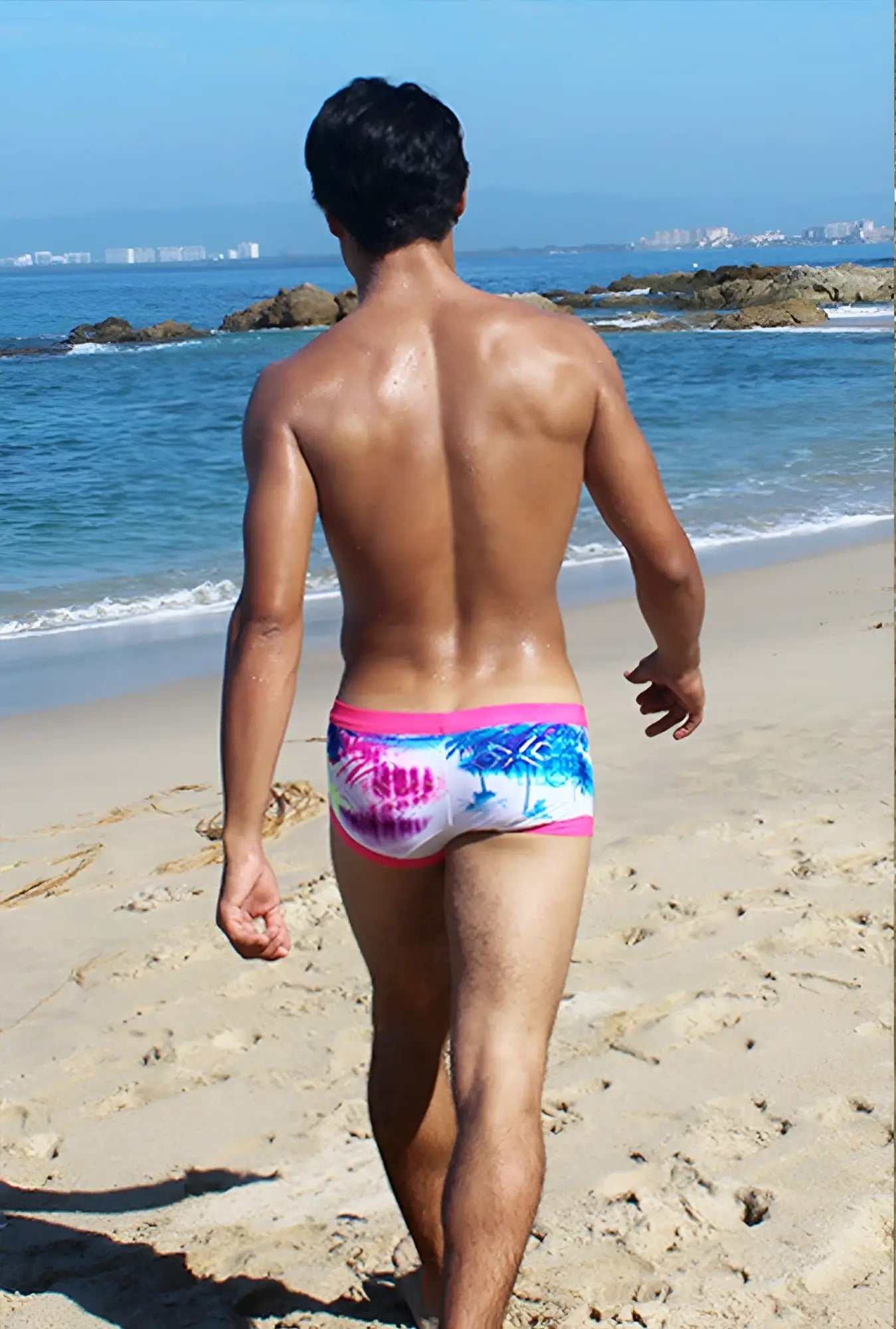 Icker Sea spring square cut trunk swimwear with pink waistband and vibrant blue palm tree pattern on white background
