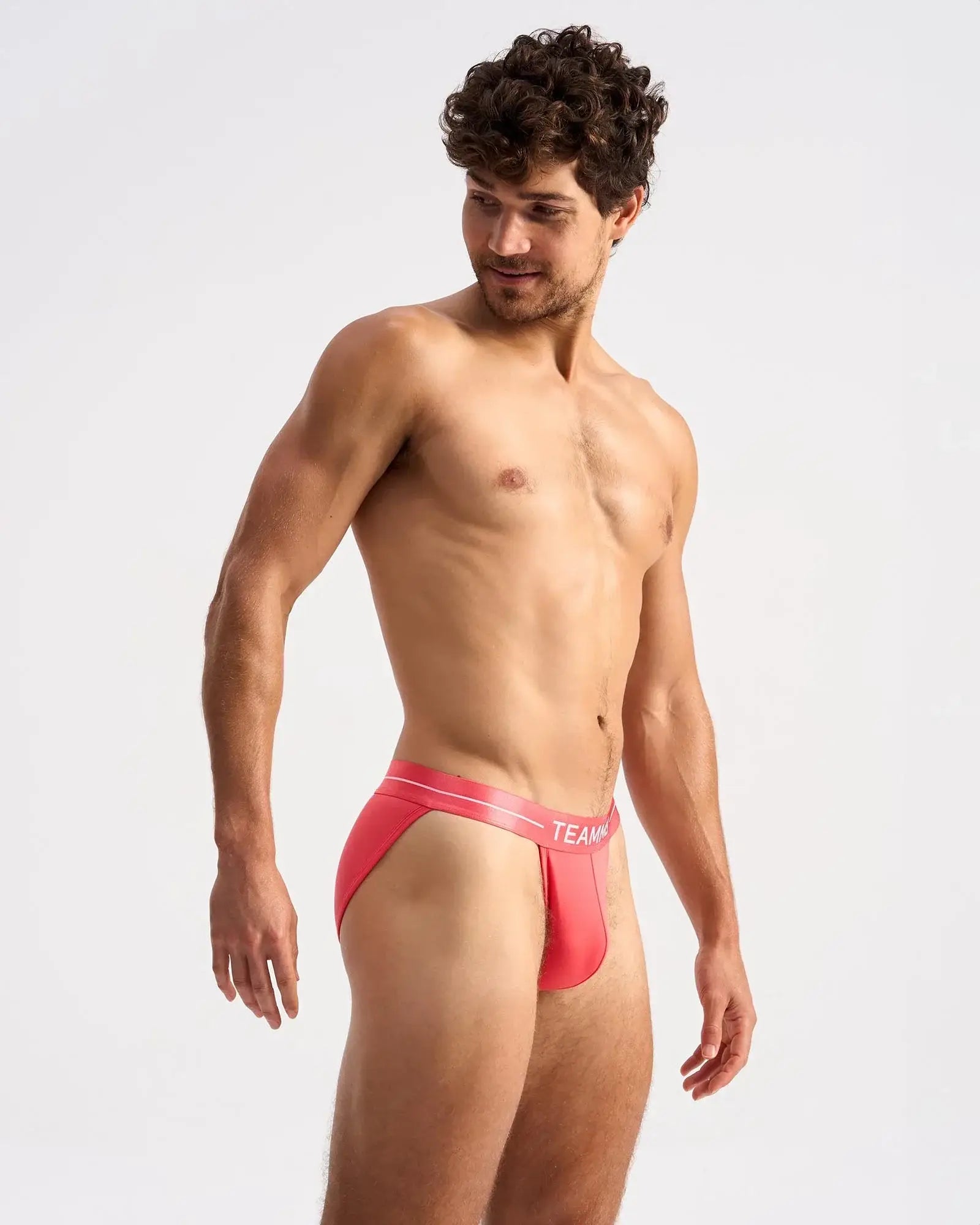 Bright coral-red form-fitting sports briefs with white elastic waistband featuring team logo for active wear