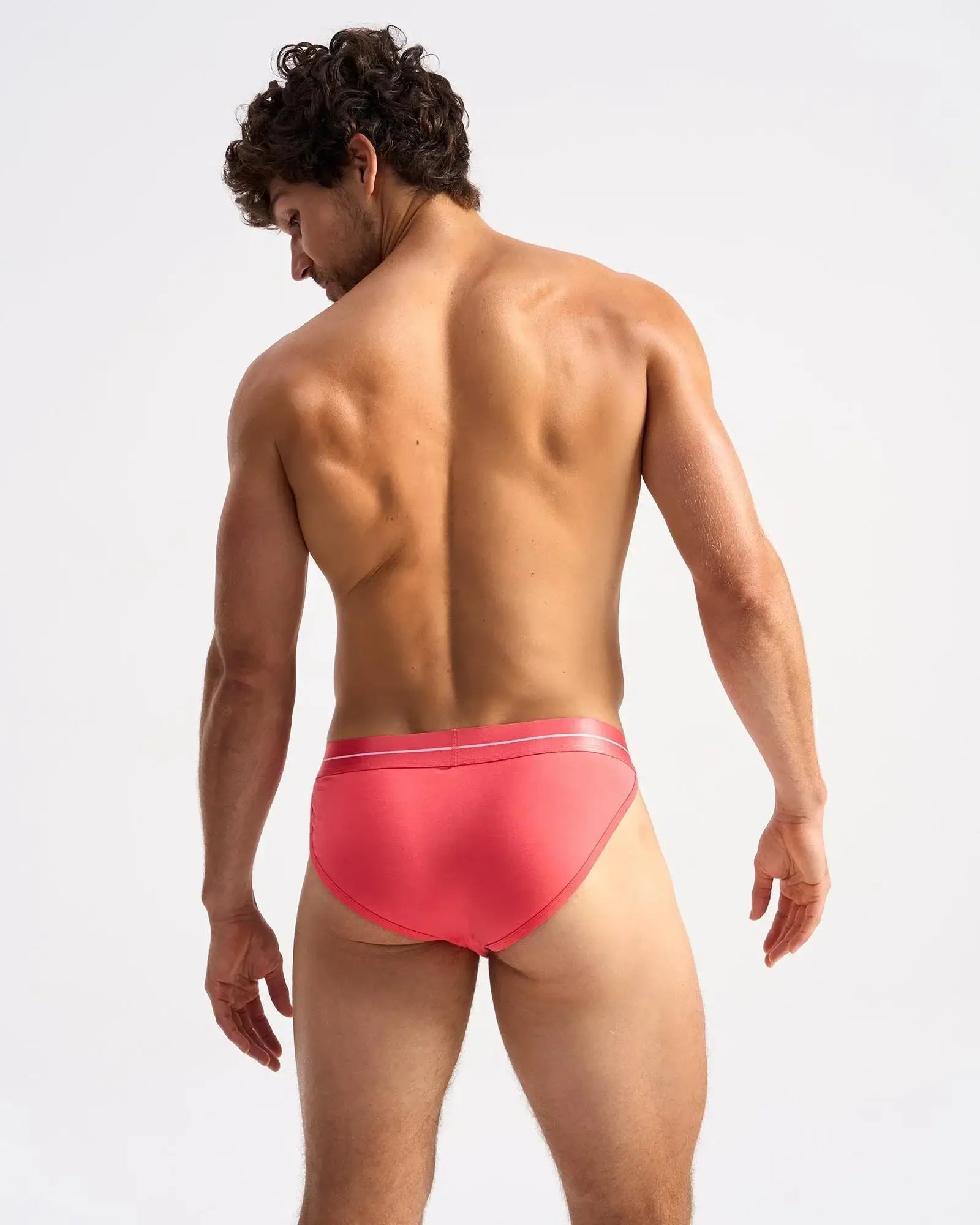 Icon sports brief coral color with sleek smooth fabric and subtle white trim along the waistband
