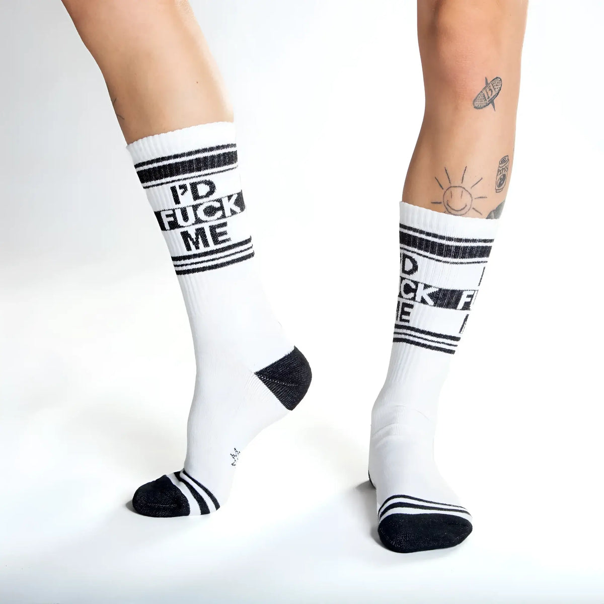White crew socks with black text reading id fuck me and matching black stripes toe caps and heel accents