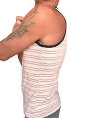 A man wearing a light gray stripe yummy nautical fleece sustain tank top with beige and gray stripes and black trim