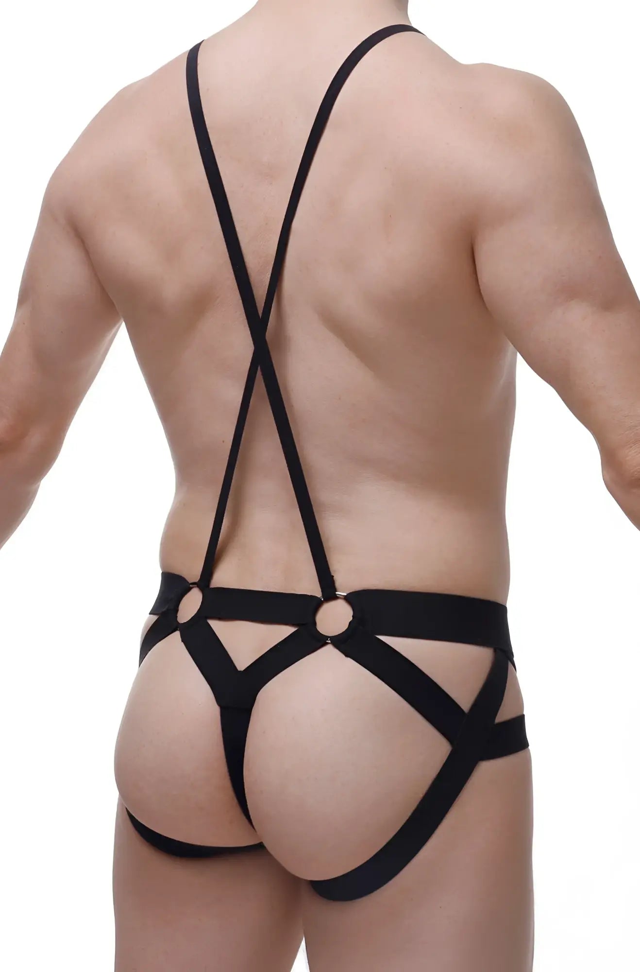 Black strappy harness-style jockstring suspenbust briefs with crisscross back straps and metal rings shown from back