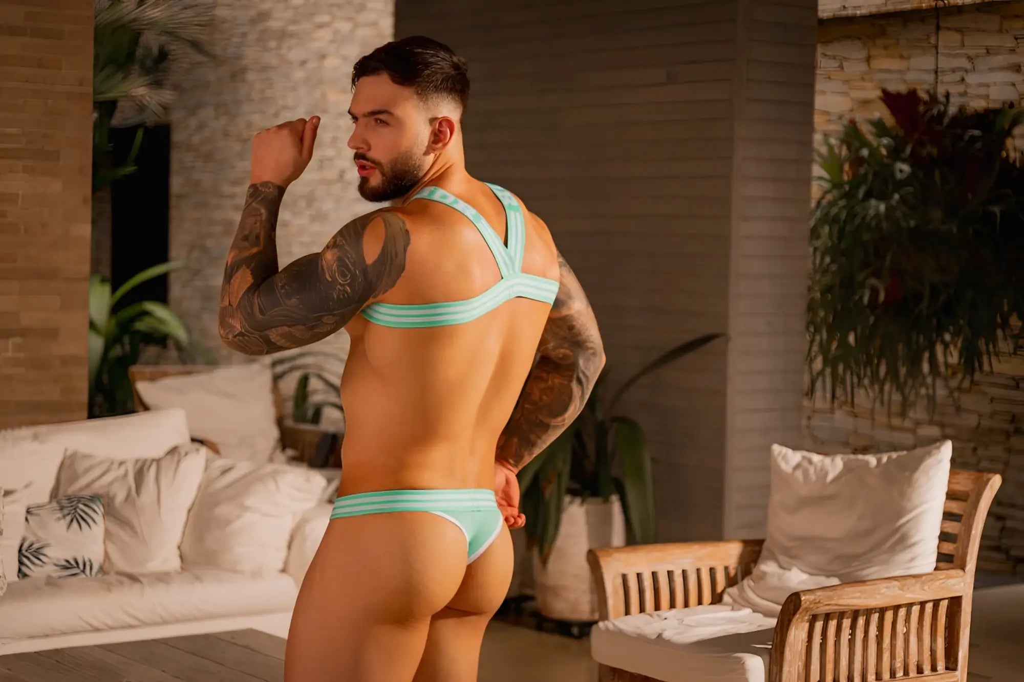 A man wearing jor 2323 college thongs in mint with thin fabric straps and a snug bikini-style fit