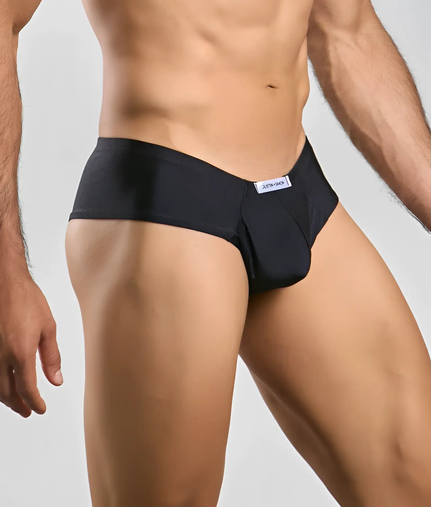 Black jockstrap from Justin + Simon Cheek with a sleek form-fitting design and subtle white brand tag at the waistband