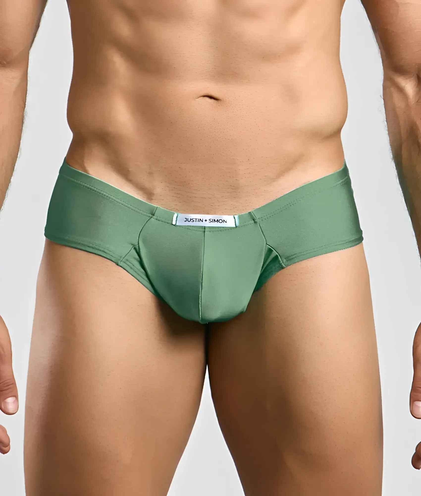 Green justin simon cheek briefs with smooth form-fitting fabric and white label on the waistband