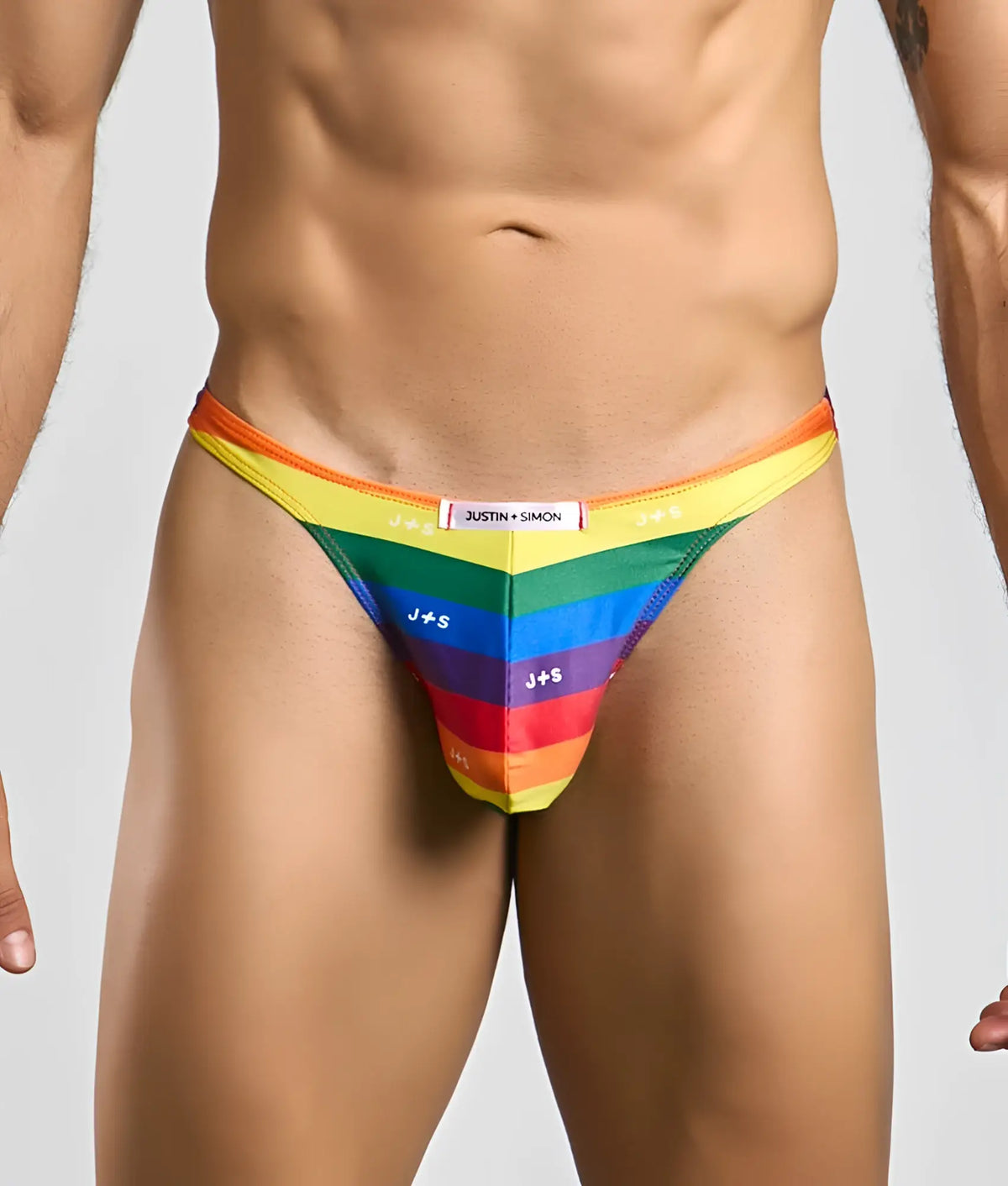Rainbow-striped men’s thong by justin + simon featuring bold vibrant colors and a sleek form-fitting design