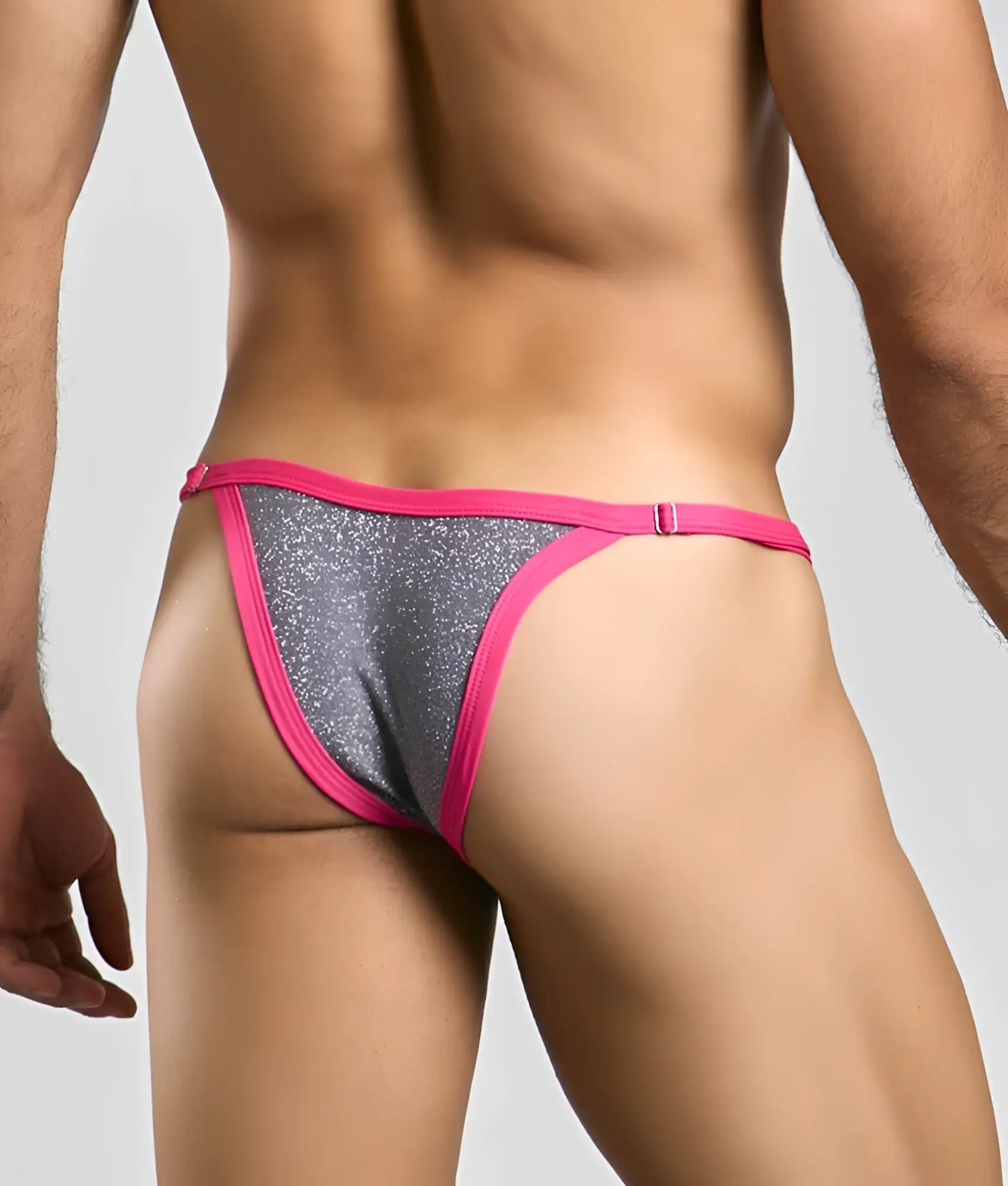 A vibrant pink and silver glitter thong from the justin plus simon bikini one collection with a snug fit