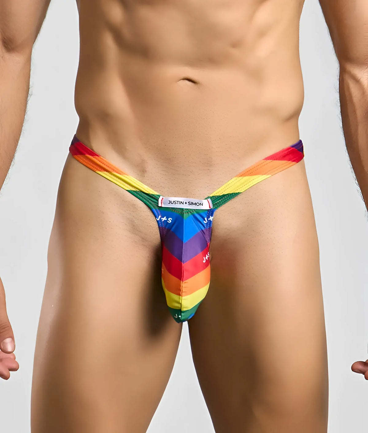 Rainbow-striped bulge thong by justin + simon showing the back side in vibrant rainbow colors with sleek design