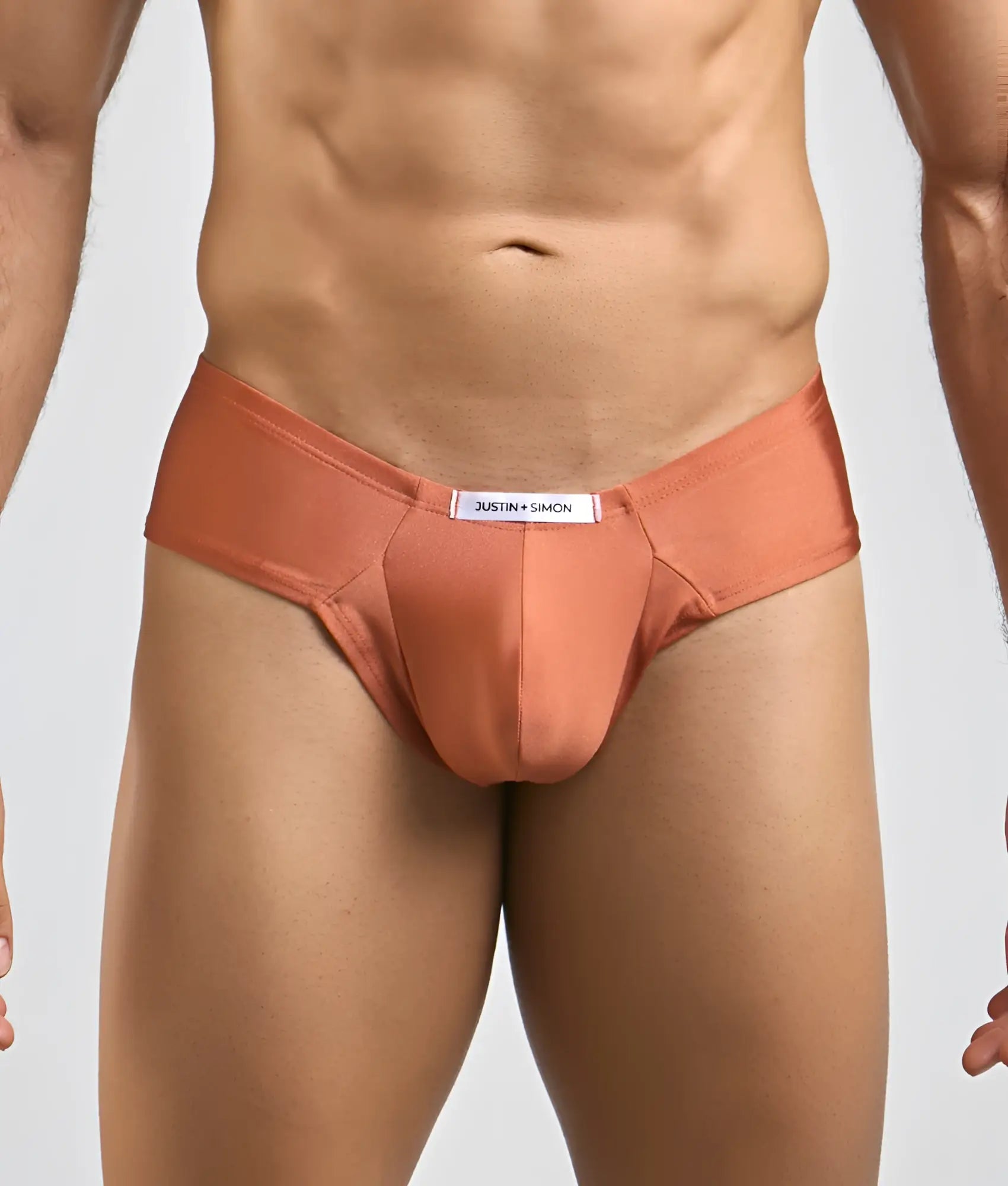 Coral-colored smooth-textured men’s briefs with branded waistband label from justin and simon cheek collection