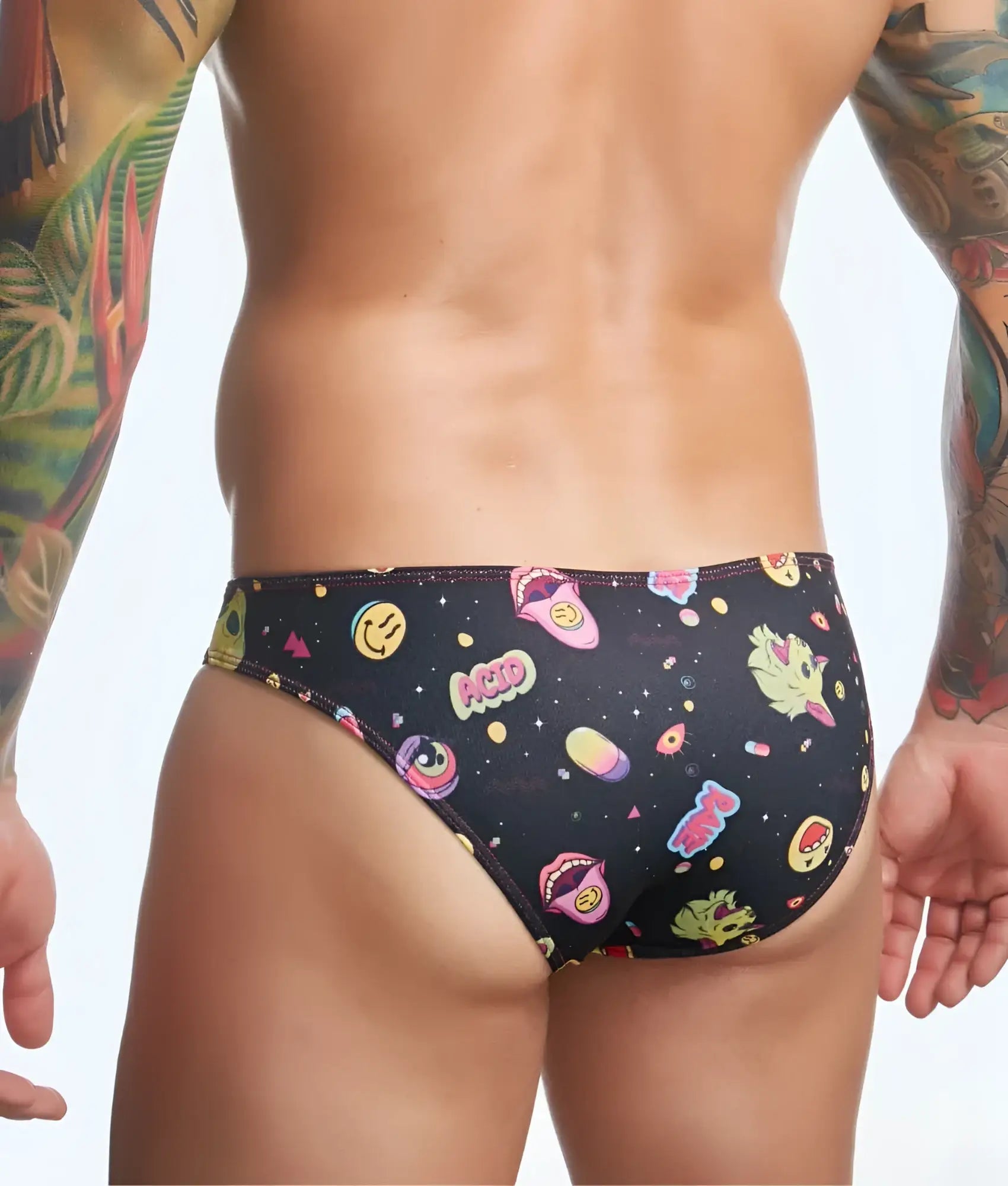 Black swim trunks by Justin + Simon featuring a playful pattern of smiling faces lips and space-themed graphics