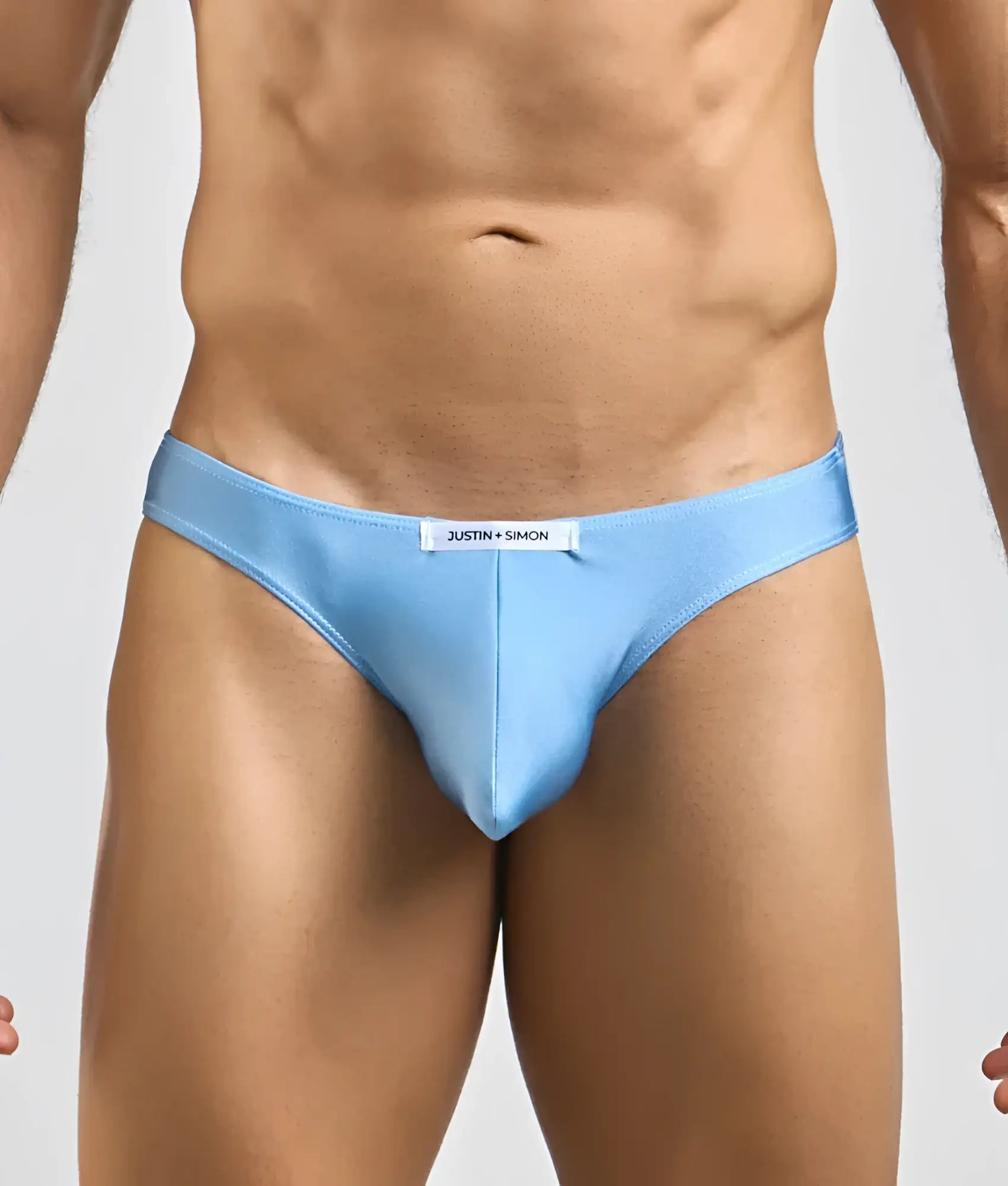 Light blue Justin + Simon classic mens bikini briefs with sleek form-fitting design and subtle brand tag at waistband