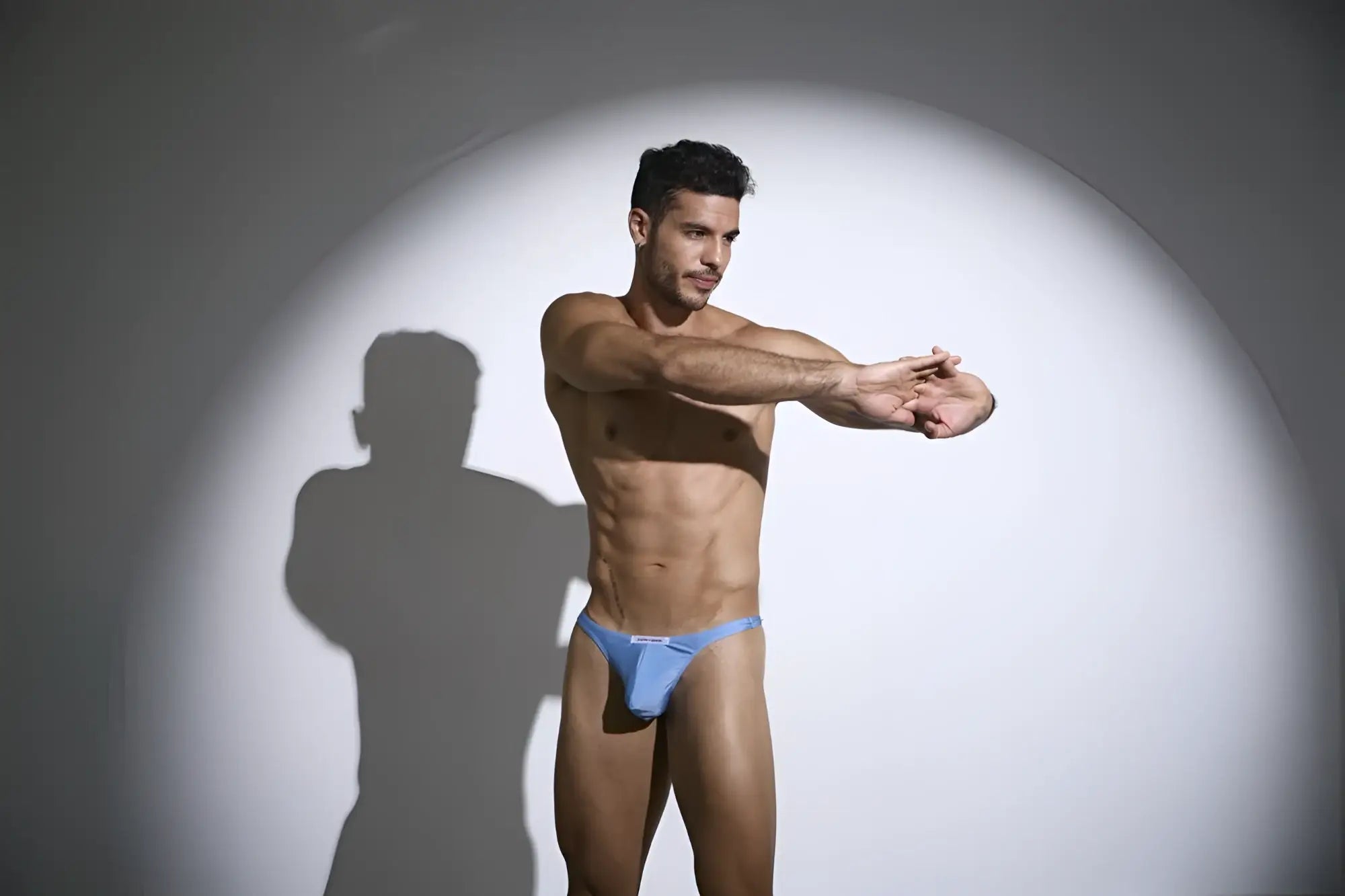 A man wearing justin simon xsj03 classic baby blue form-fitting briefs with a small white logo on the front