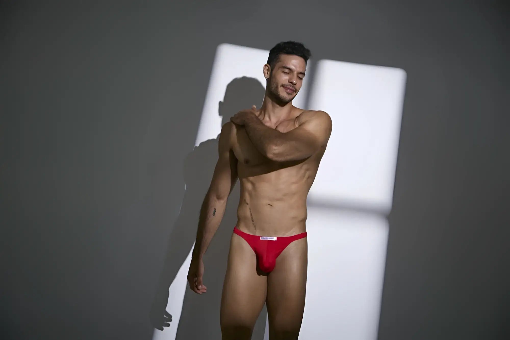 Justin+Simon XSJ03 classic thongs in peach red with a white logo on the waistband showing the back side