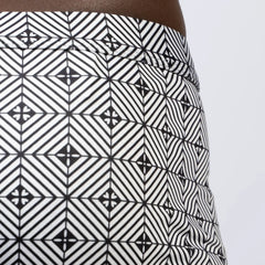 Black and white geometric patterned kaleidoscope sq cut trunk skirt featuring a bold repeating diamond design