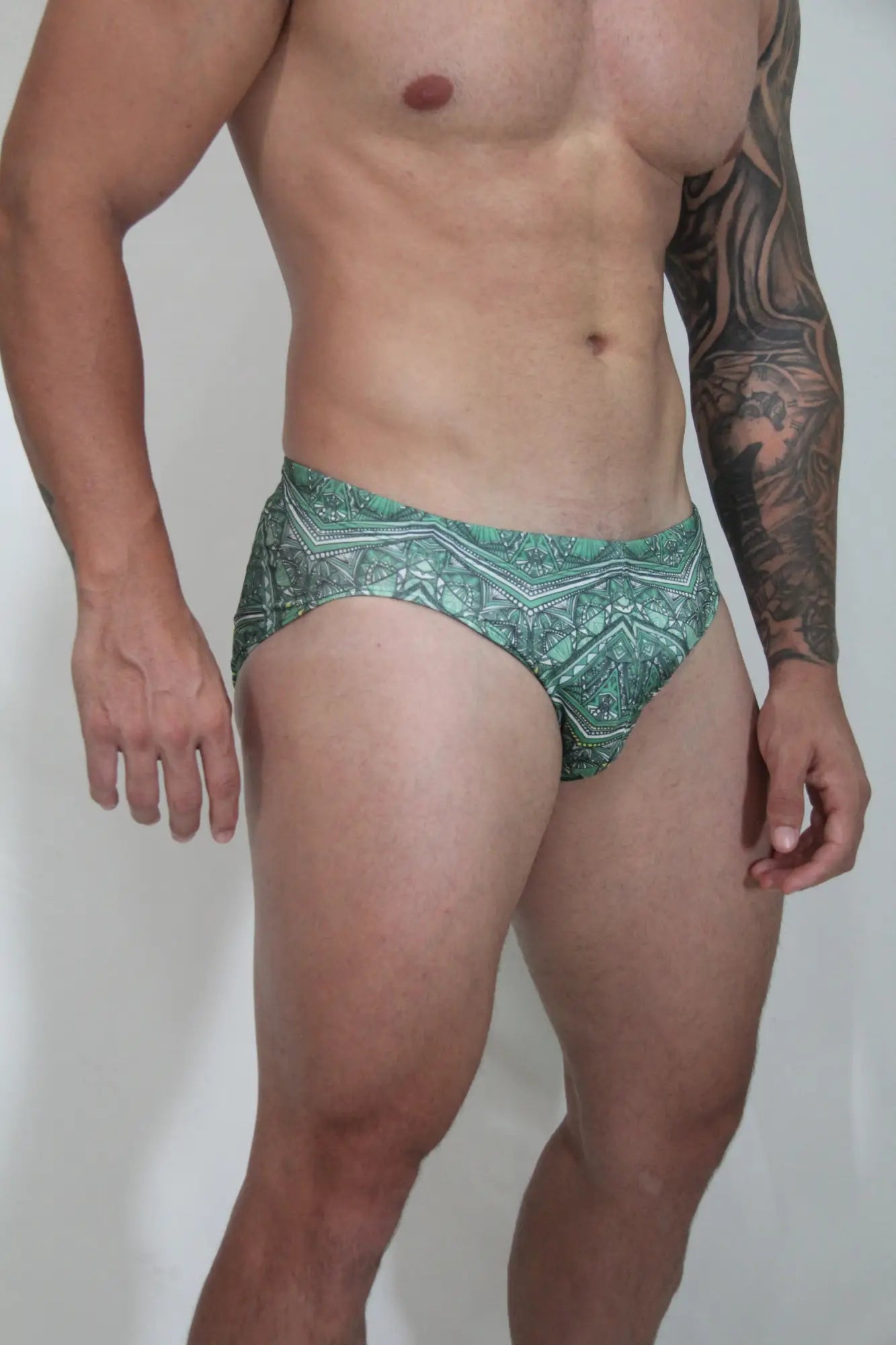 Green patterned kaleidoscope swim brief with intricate geometric designs for stylish swimwear use
