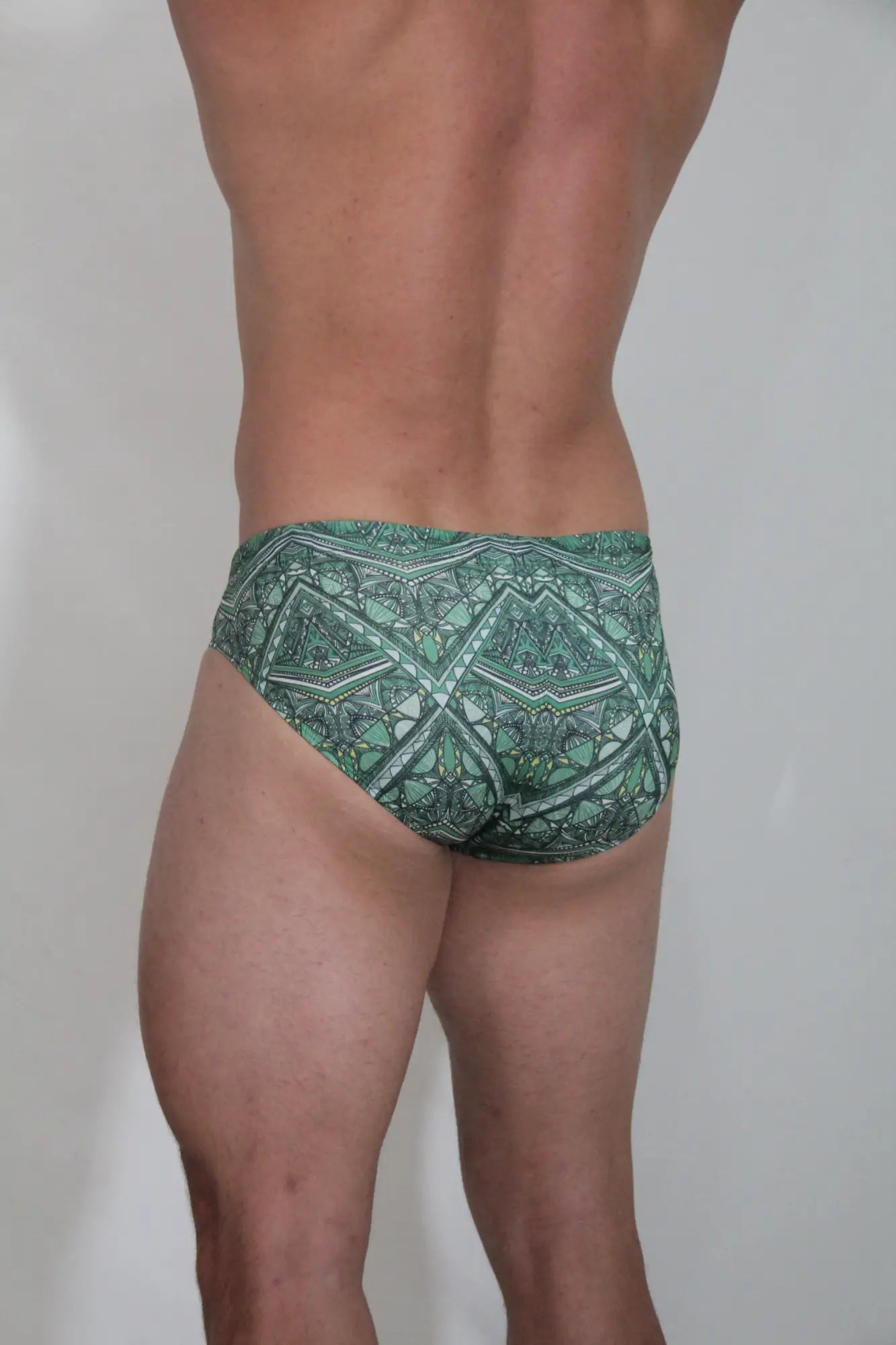 Kaleidoscope swim brief in green featuring intricate geometric and tribal-inspired patterns for stylish beachwear