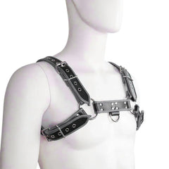 White male mannequin wearing a black leather contrast trim harness with silver buckles and hardware.