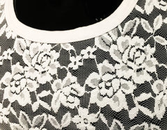 White floral lace tee with black base and rounded white neckline showcasing delicate lace detail on front
