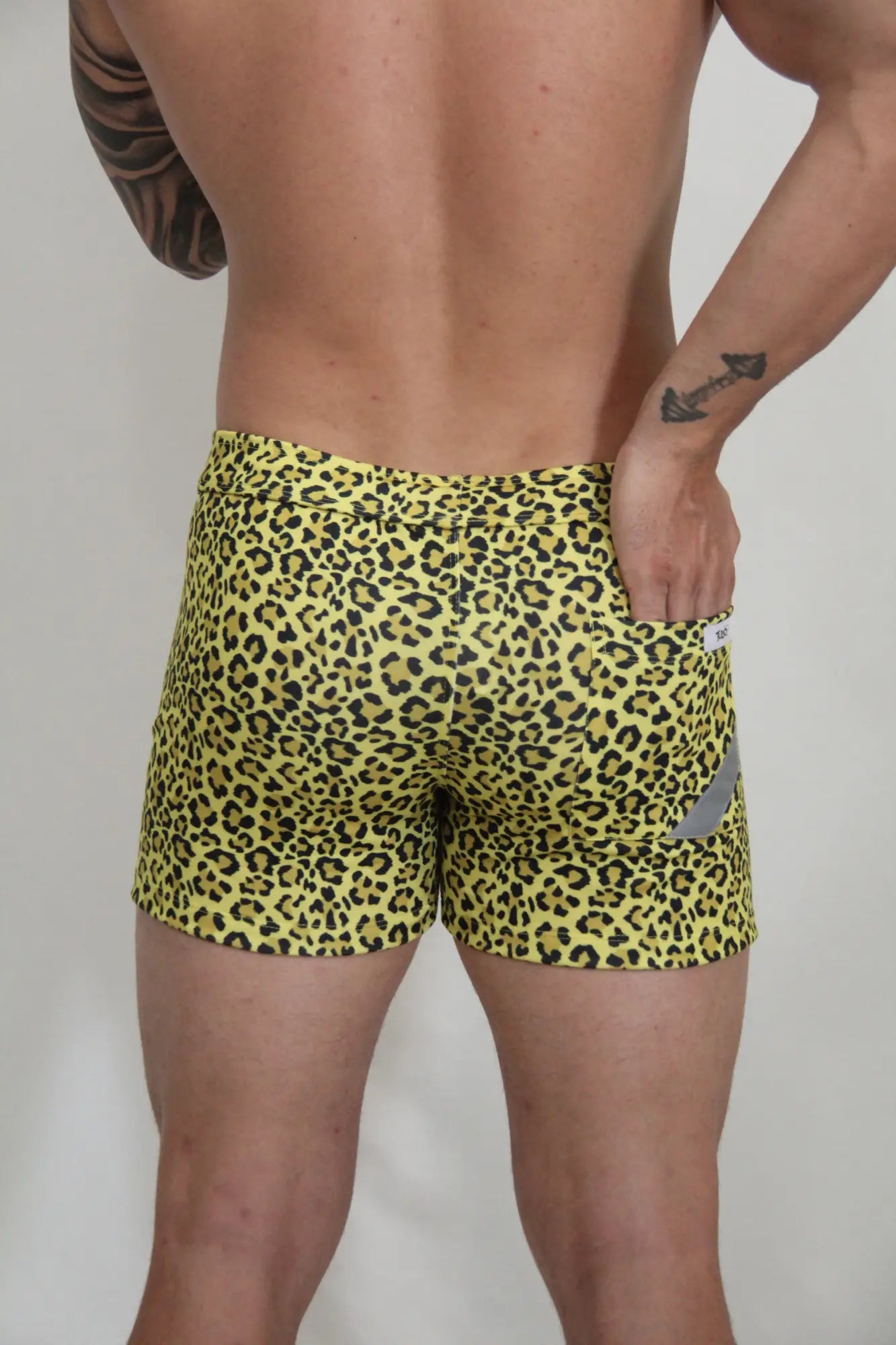 Yellow leopard-print fleece shorts with snug fit and small gray reflective patch on the side for casual wear