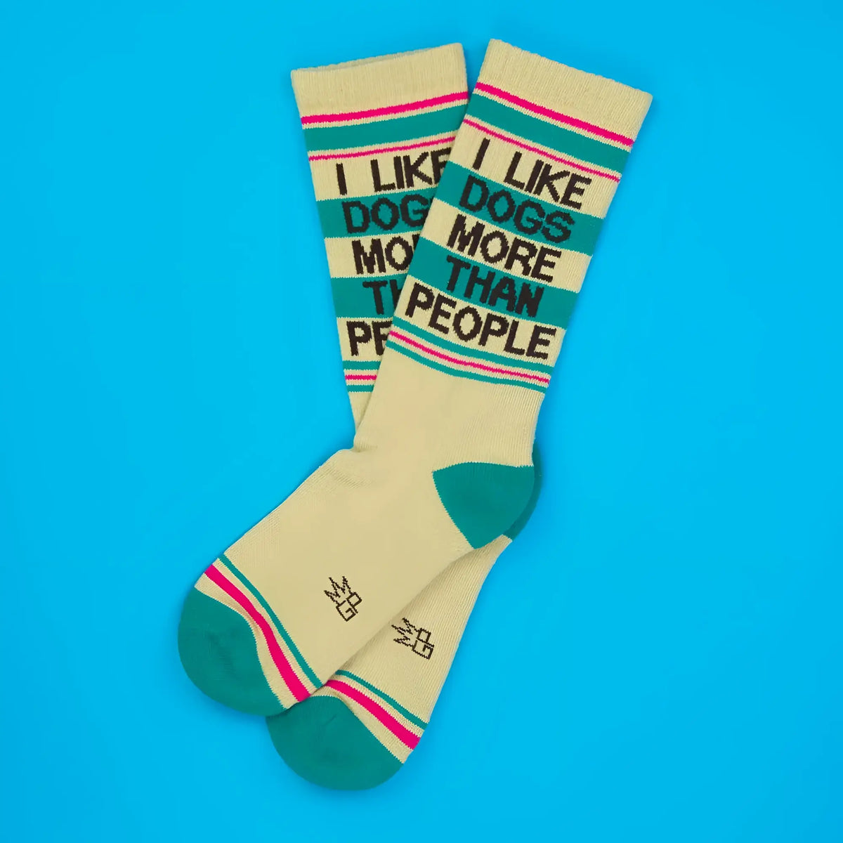 Cream-colored crew socks with teal and pink stripes featuring i like dogs more than people text in black lettering