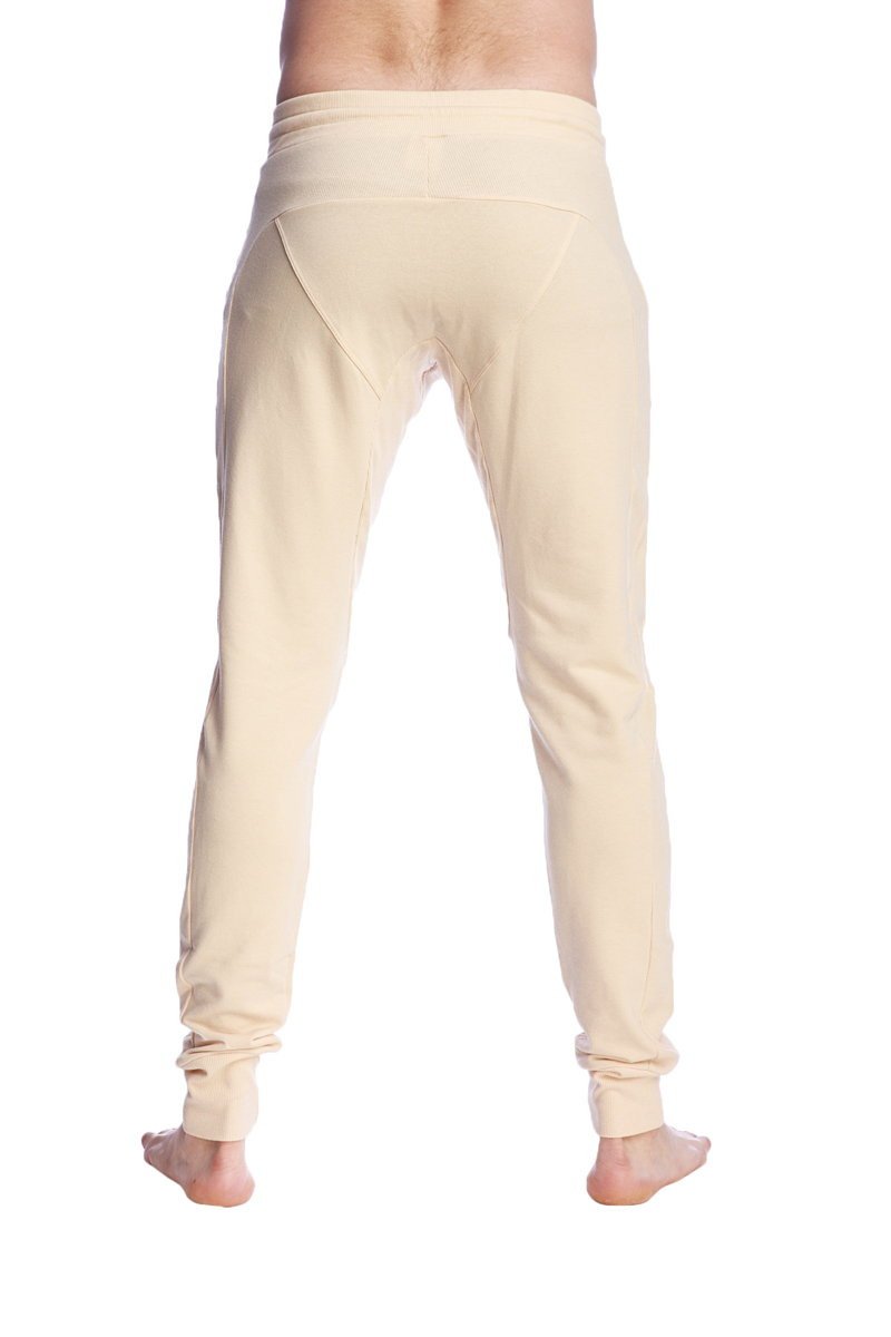 Cream-colored long cuffed jogger and yoga sweat pants in stretchy fabric with tapered fit and rolled cuffs