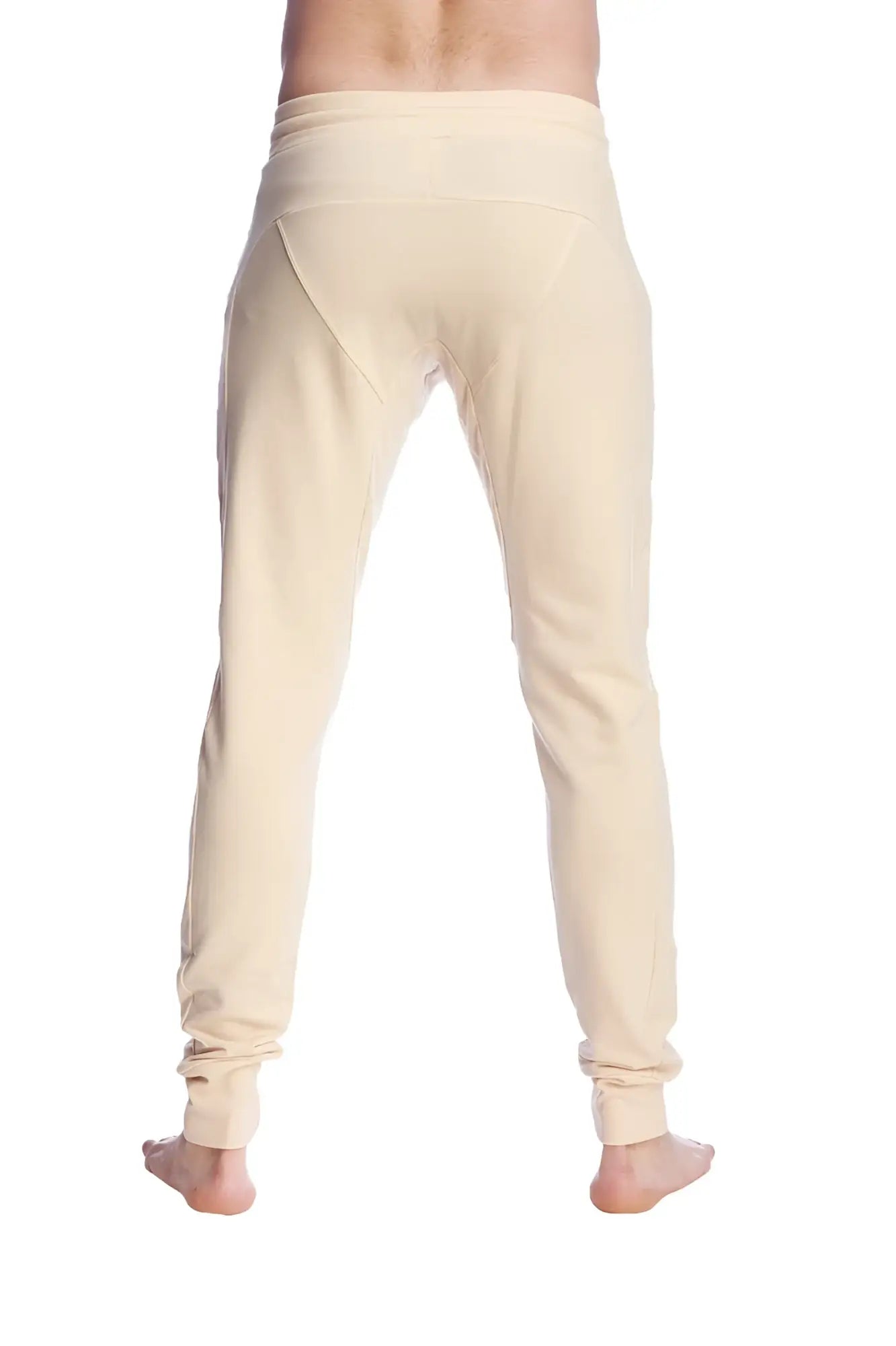 Cream-colored long cuffed jogger and yoga sweat pants in stretchy fabric with tapered fit and rolled cuffs