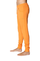 Long cuffed jogger and yoga sweat pants in sun orange made of bright soft fabric with drawstring waist and rolled cuffs