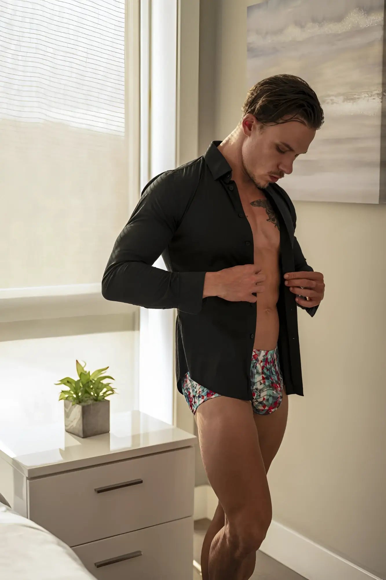 Man wearing male power 131-293 your lace or mine red white blue floral pouch short with black long-sleeved shirt