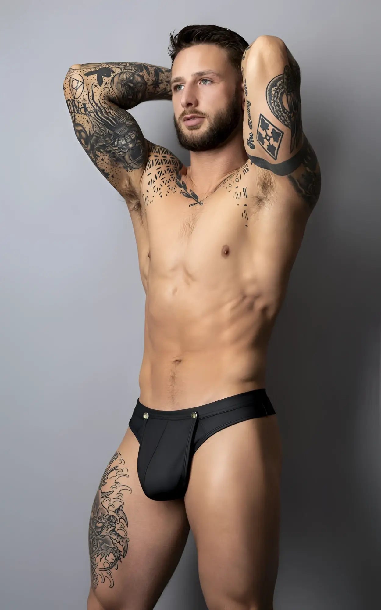 Black sleek form-fitting male power 410-298 oh snap snap off thong with subtle metallic button detail at waistband