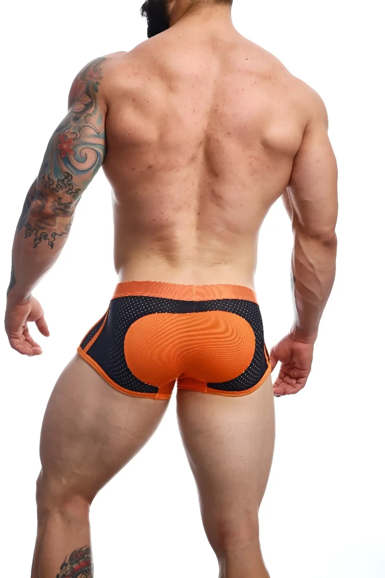 Back view of malebasics spot new sexier trunk pink mesh briefs with textured padded orange panel