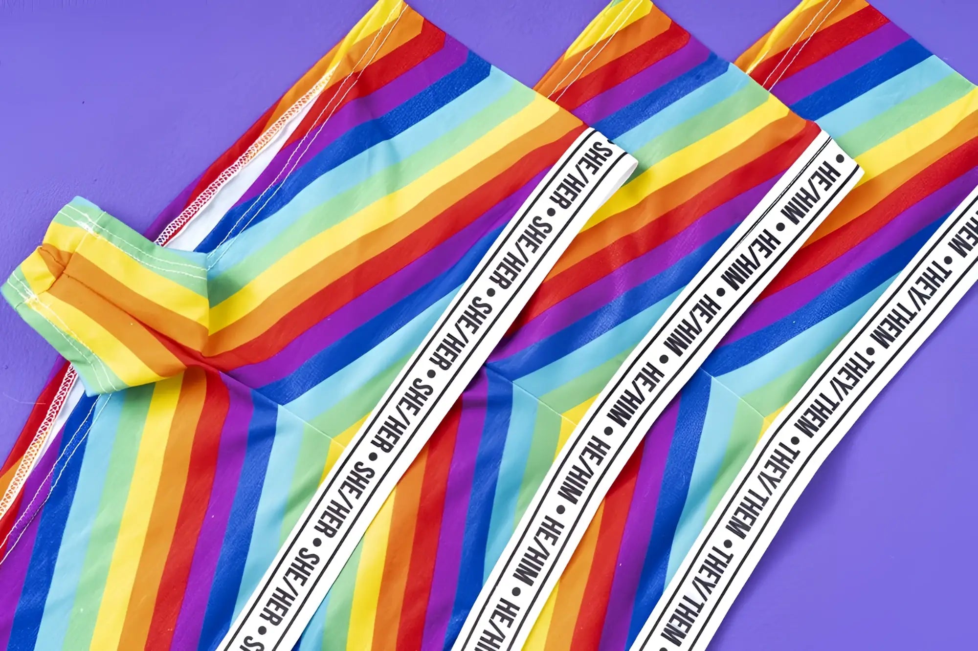 Mapale 122b rainbow cheeky short leggings with rainbow stripes and white elastic waistband with she her and they they text