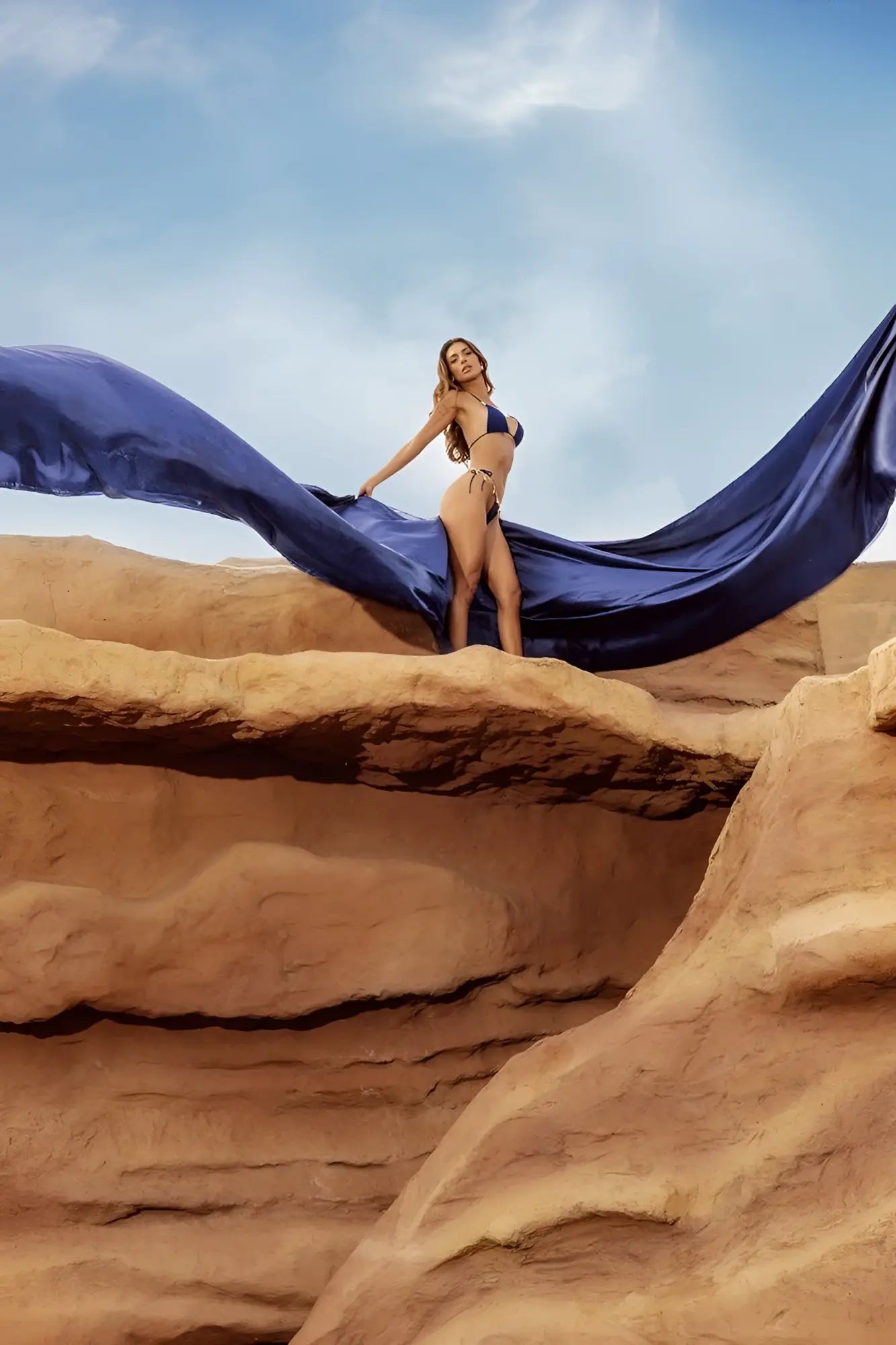A woman in a deep ocean mapale 67158 two piece swimsuit holds flowing fabric on red rock formations