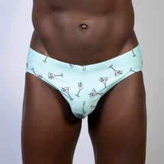 Mint green martini swim brief with playful pink martini glass pattern and black outlines for swimwear use