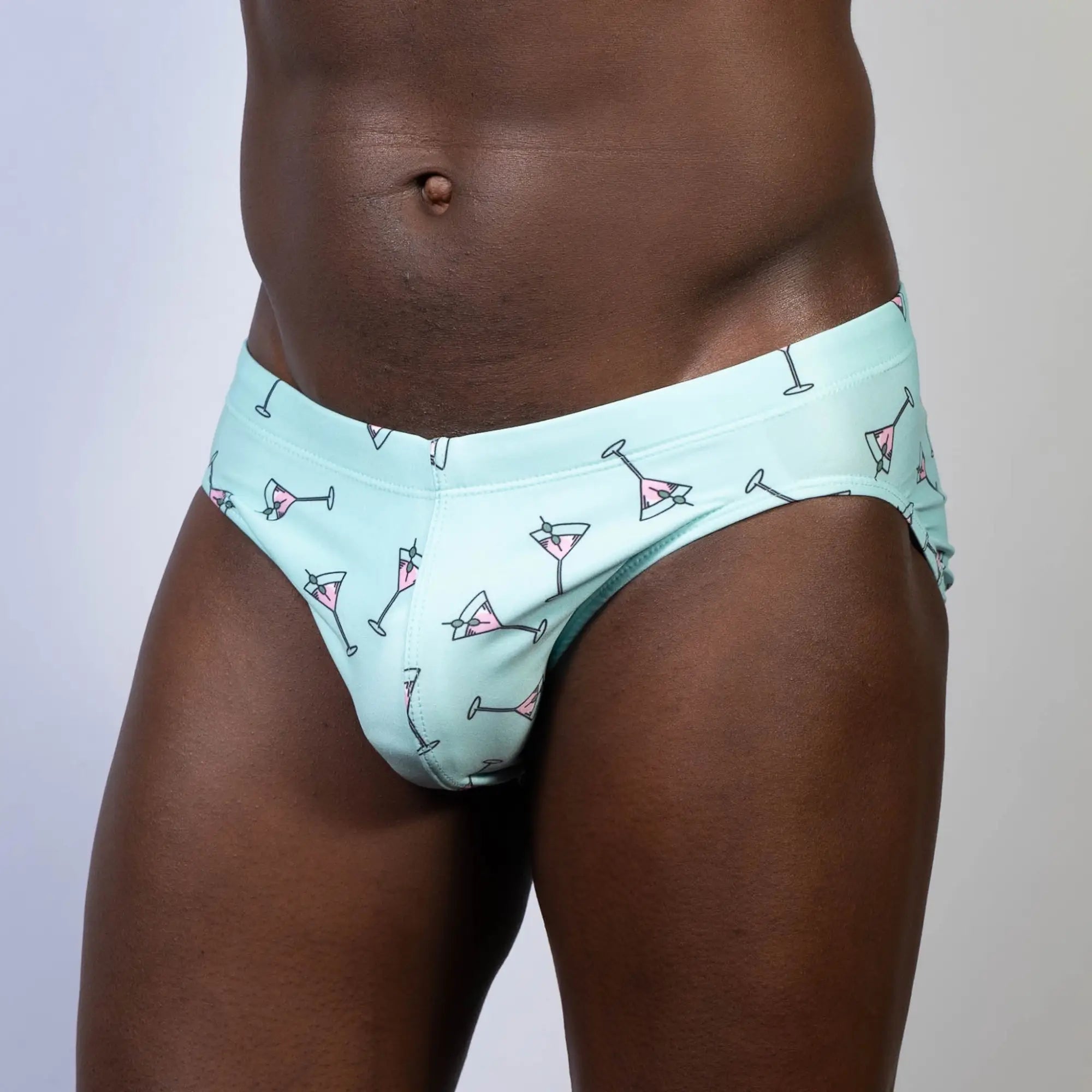 Mint green swim brief featuring a playful pink martini glass pattern perfect for stylish beachwear