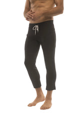 Mens solid black 4/5 zipper pocket capri yoga pants with white drawstring waistband and cropped fit