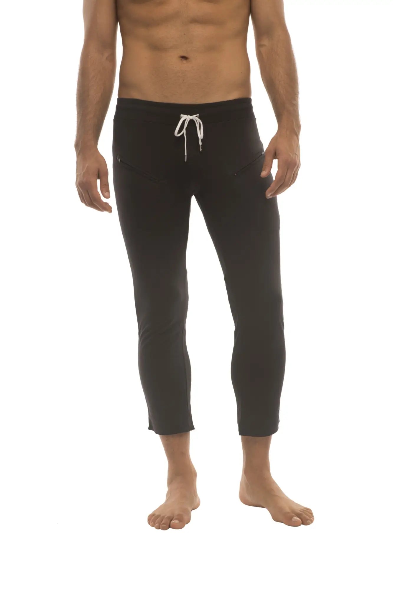 Mens solid black capri yoga pants with 4 5 zipper pockets and a white drawstring waistband