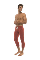 Mens solid cinnabar red capri yoga pants with white drawstring waistband and side zipper pockets