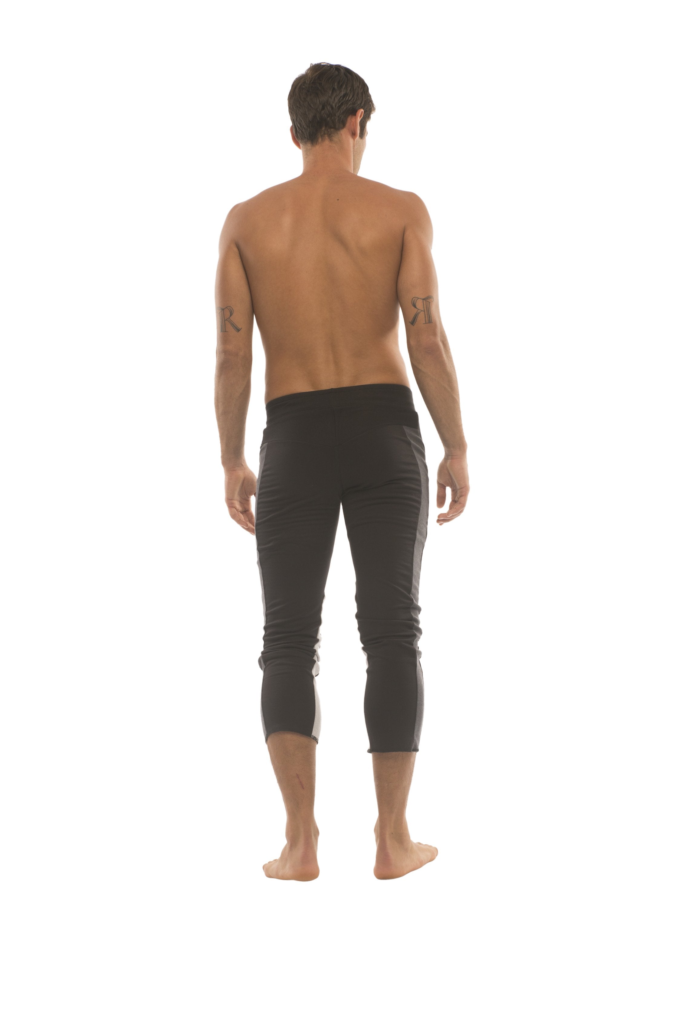 Mens black capri yoga pants with sleek form-fitting design and subtle charcoal and grey side stripes and zipper pockets