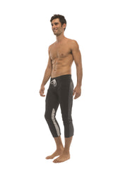 Mens black capri style swim trunks with white drawstring and gray side stripes for active wear