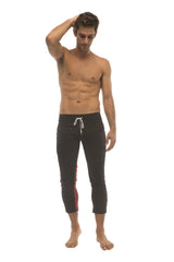 Mens black capri swim trunks with white drawstring and red side panels for activewear and casual use