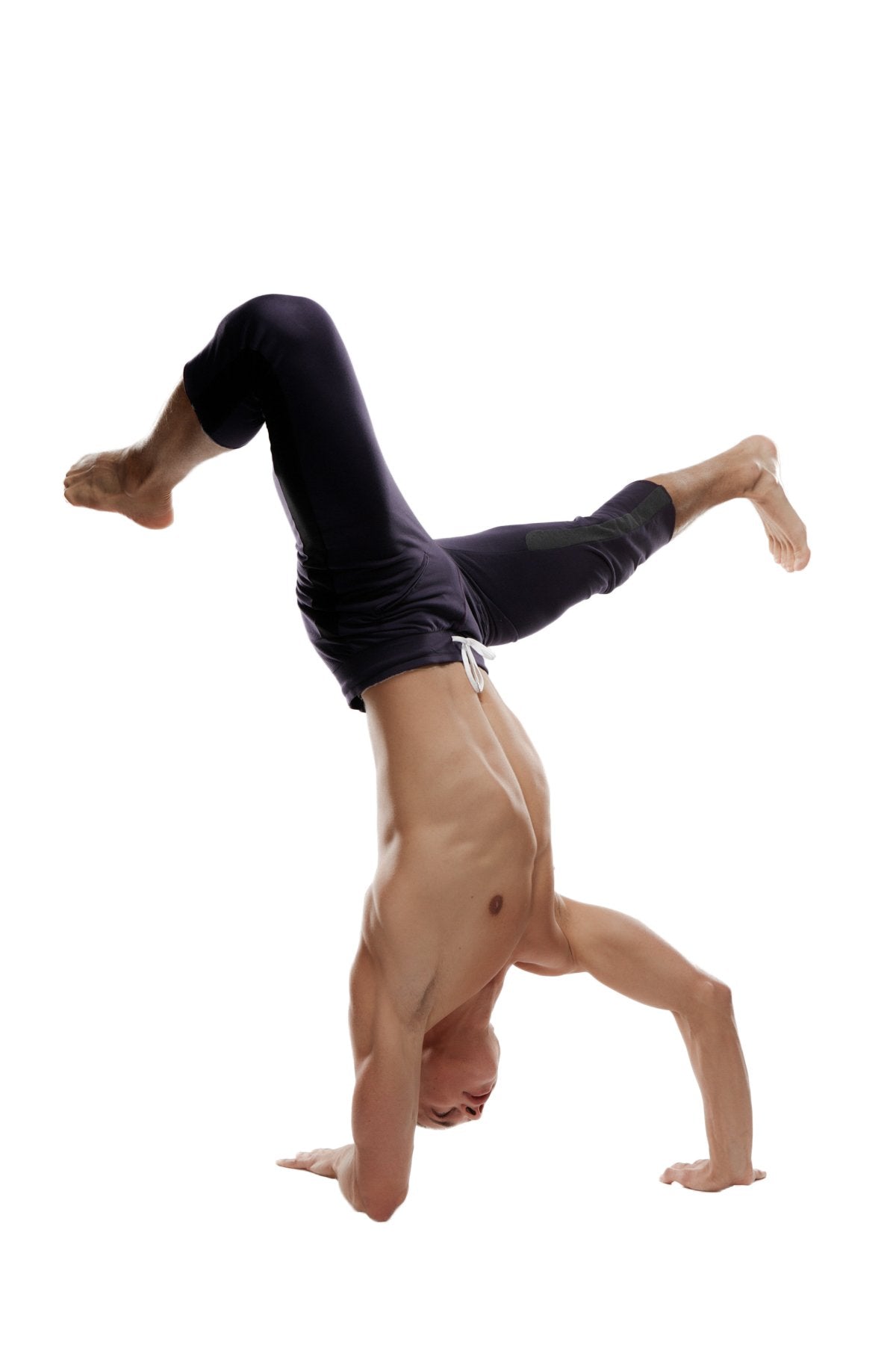A muscular man performing a handstand wearing black mens 4/5 zipper pocket capri yoga pants for active use