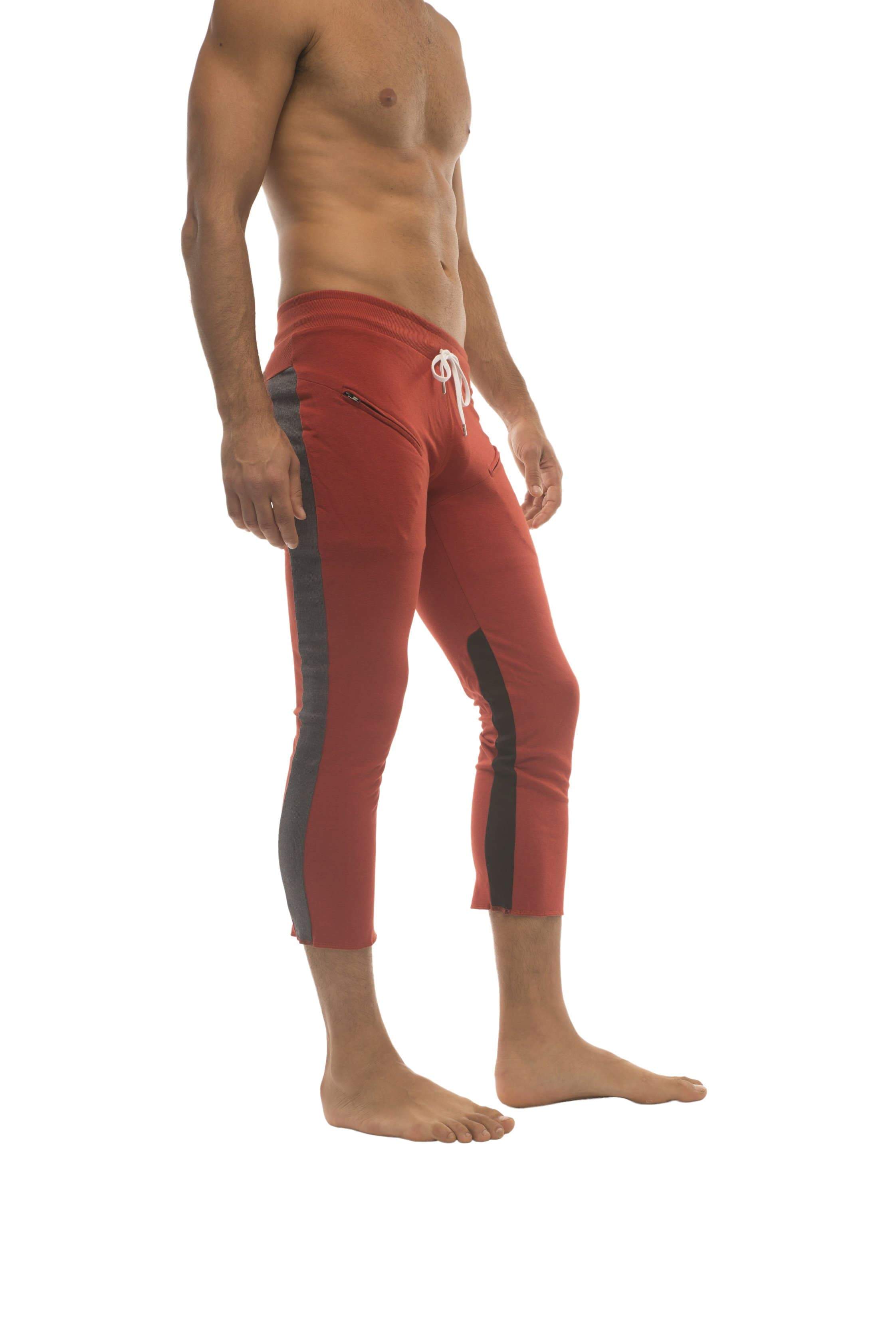 Mens red athletic capri yoga pants with black side stripes and white drawstring waistband for active wear