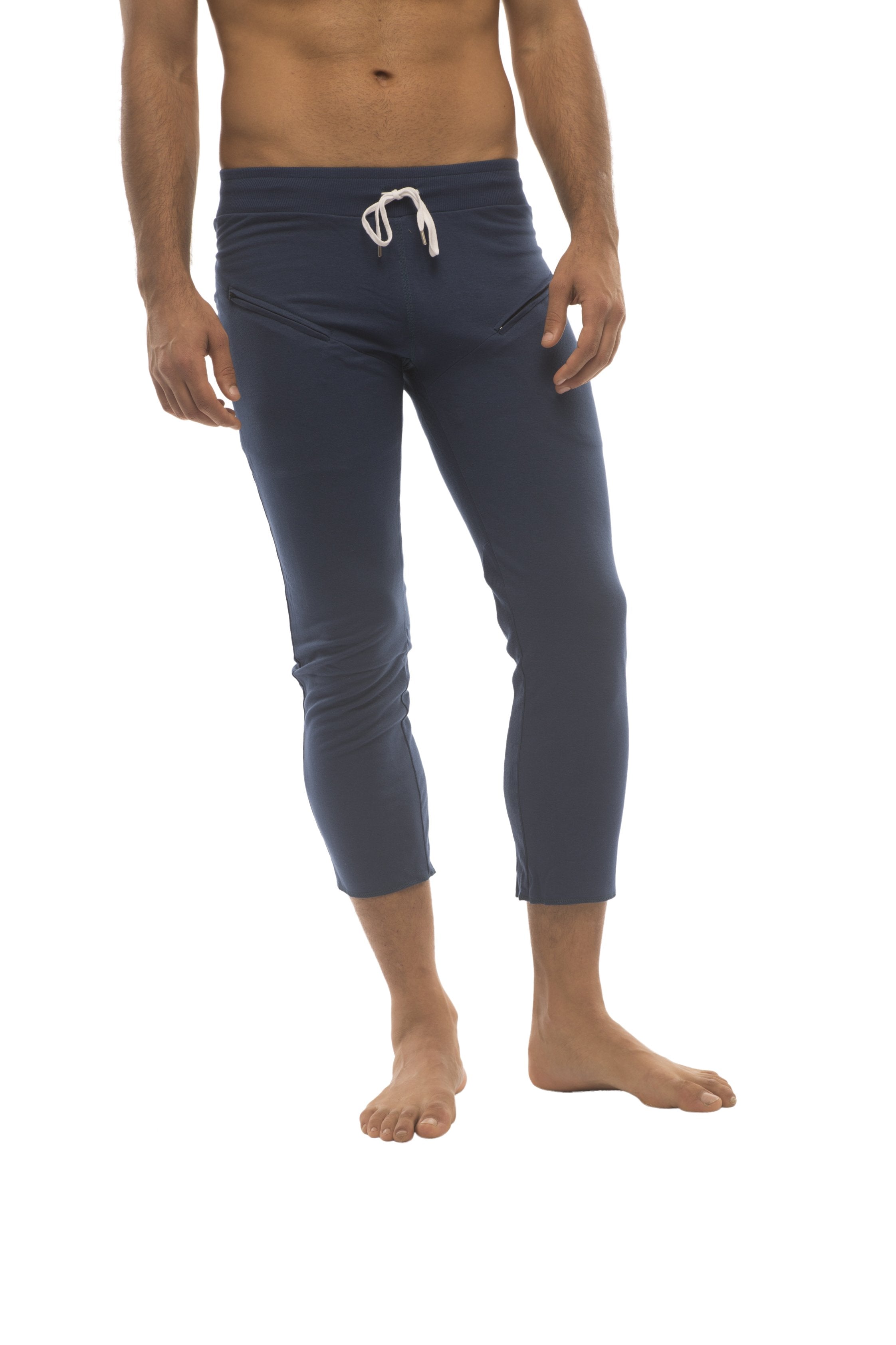 Mens solid royal blue capri yoga pants with a white drawstring waistband and 4/5 zipper pockets for athletic use