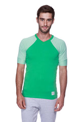 Mens green v-neck t-shirt with light green striped raglan sleeves paired with heather grey green yoga pants