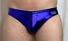 Vibrant royal blue metallic swim brief with a sleek shiny finish and a small white logo on the waistband