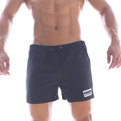 Black athletic swim shorts with drawstring waistband and white logo patch on lower right leg from metromalewear