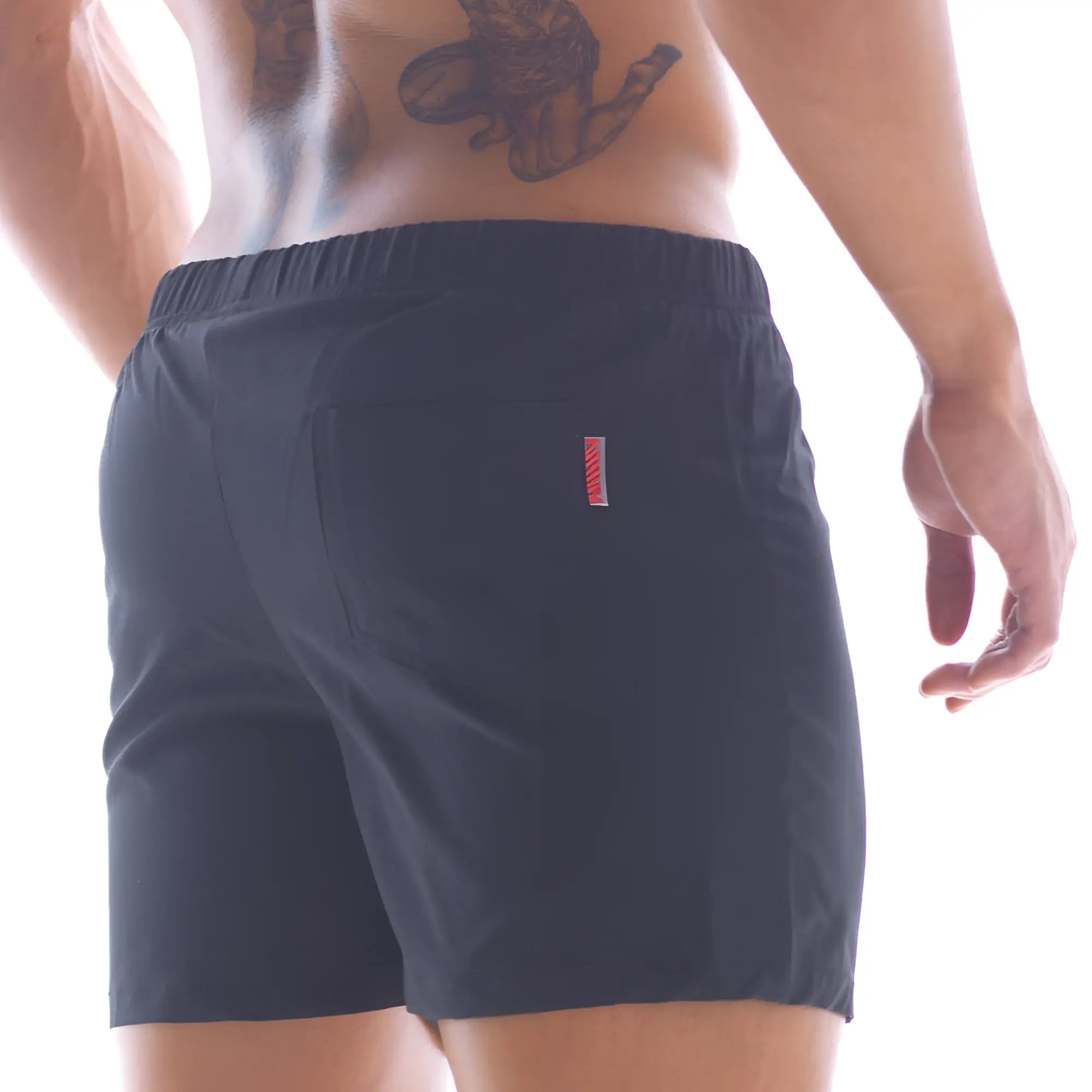 Back side of metro malewear flexible swim trunk black 4710-20 showing dark navy shorts with red and white stripe pocket