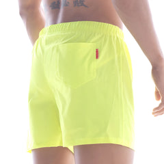 Bright neon yellow metro male wear flexible swim trunks with a small red tag on the back pocket shown from behind