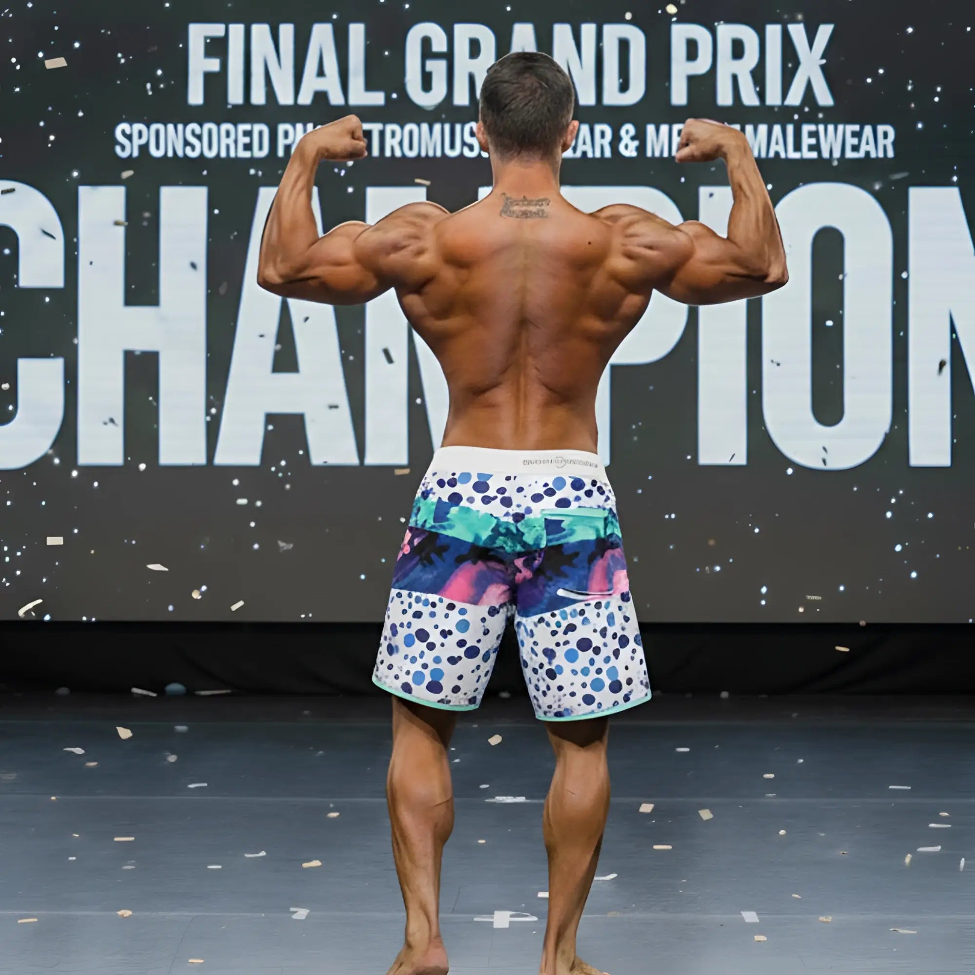 A man wearing vibrant metro male wear metro musclewear bubble physique board shorts with colorful abstract designs